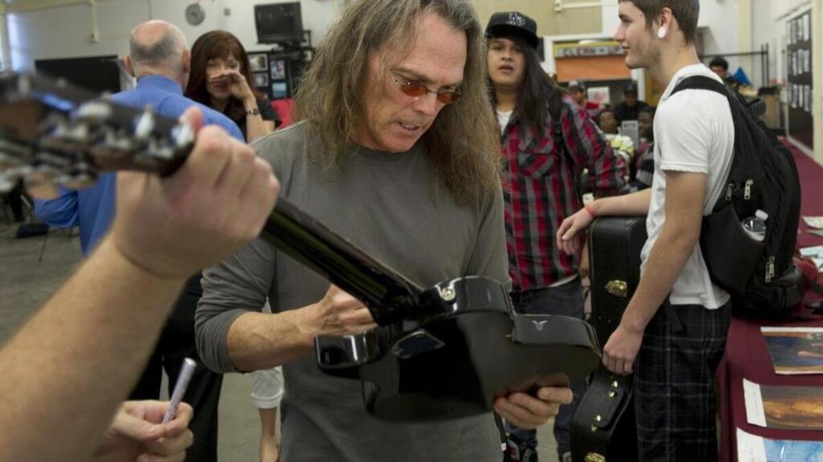 Timothy B. Schmit of the Eagles autographs a guitar during a visit to Encina High School, where he graduated in 1965, on Thursday, September 29, 2011. Schmit will be the fifth honoree in the Sacramento Walk of Stars.