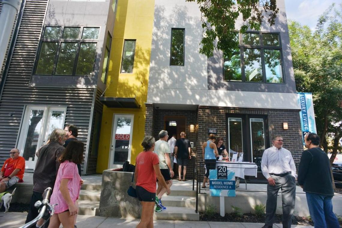 People mingle outside a model home Saturday in the new 20PQR housing development in midtown Sacramento.