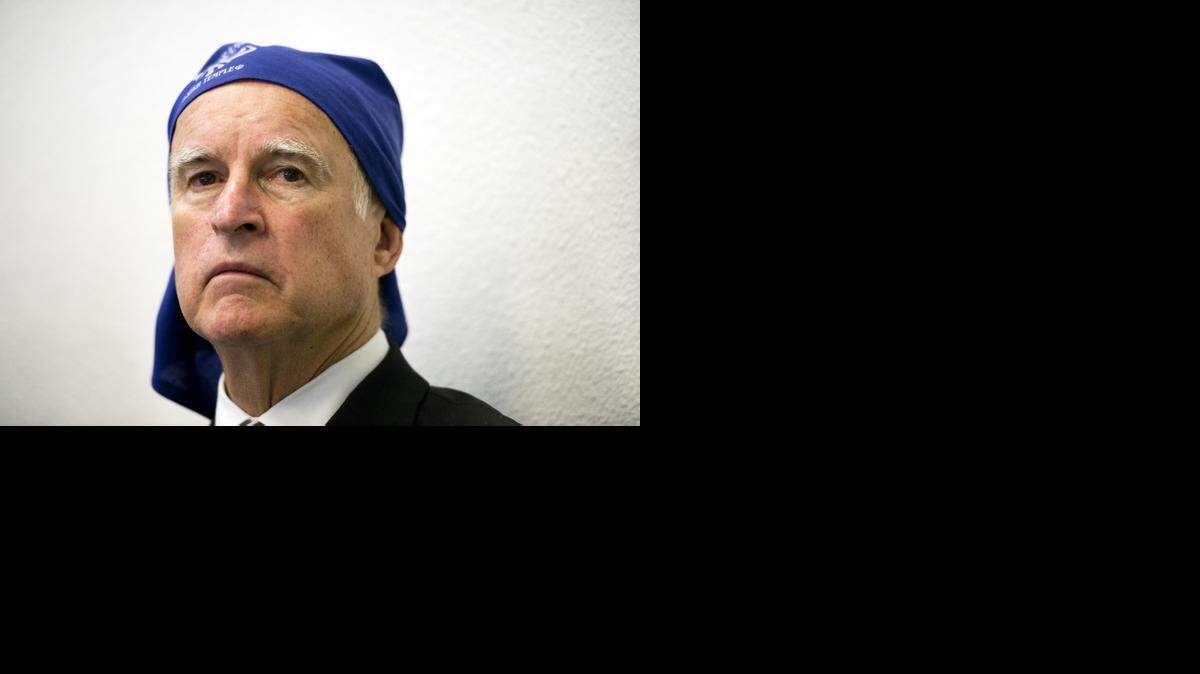 
Gov. Jerry Brown, wearing a Dastaar, waits to honor Didar S. Bains, known as the peach king of California, during a ceremony at the Sacramento Sikh temple on Sunday in West Sacramento.
