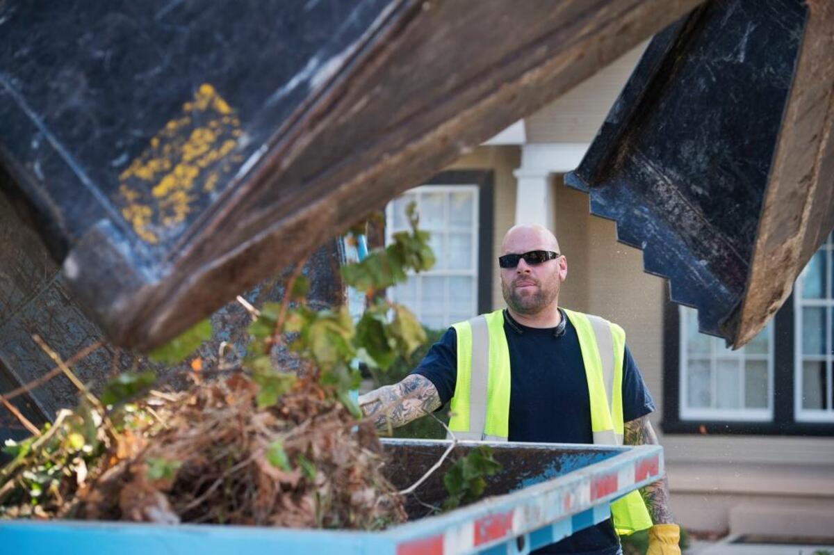 City worker Mike Robbins oversees his truck as "The Claw" releases yard trimmings in Curtis Park in 2015.
