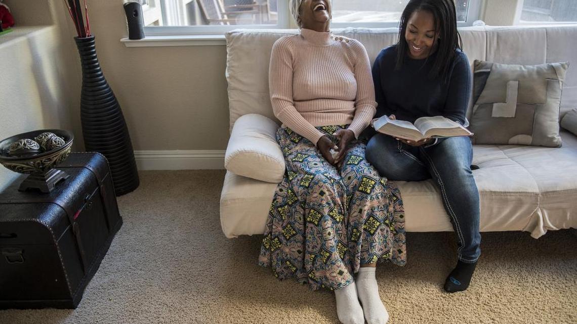 Caregiver Shay Jackson, 32, right, reads the Bible with her grandmother Audrey Strong, 79, who suffers from lung cancer.