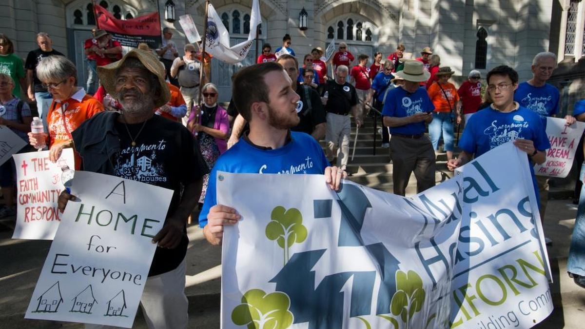 James Little, wearing hat at left, at St. John's Lutheran Church carries a sign in support of affordable housing during a pilgrimage with the Sacramento Housing Alliance and Sacramento Area Congregations Together (ACT) in 2013. ACT pledged Friday, Jan. 27, 2017, to shield undocumented immigrants from possible federal raids in the wake of tougher immigrant enforcement signed by President Donald Trump.