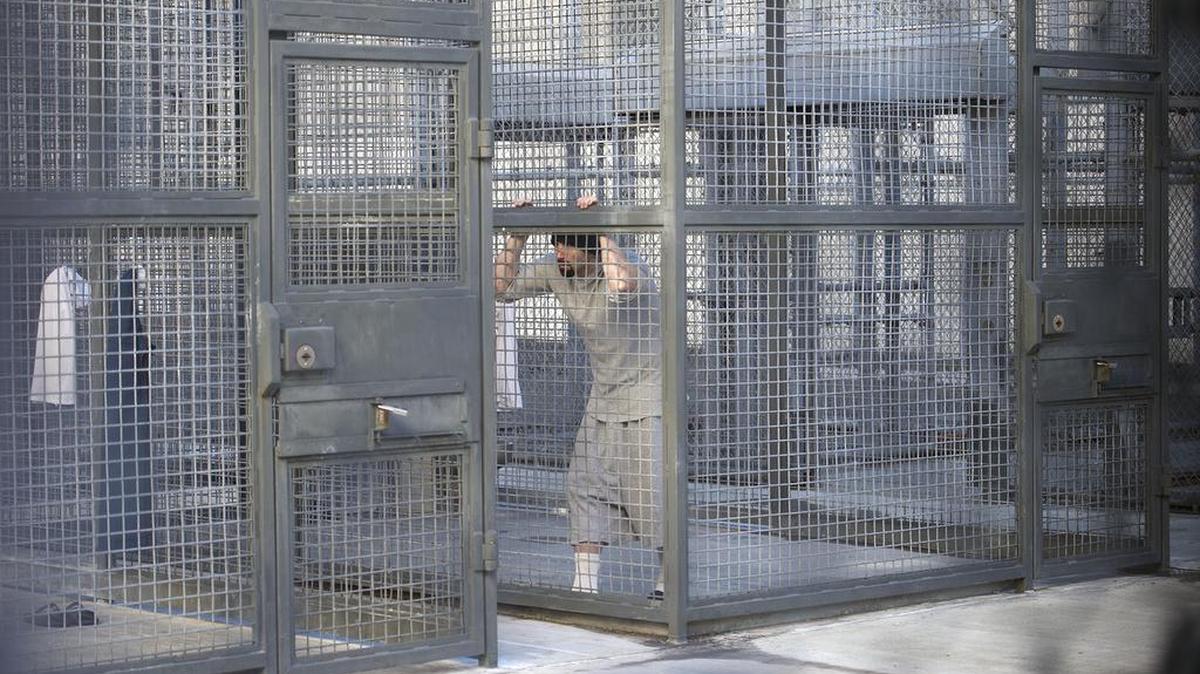 A death row inmate stands inside his solitary cage during time away from his cell at the Adjustment Center.