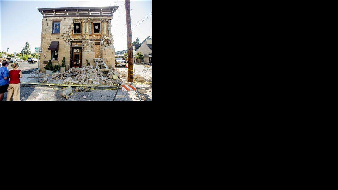  In this Aug. 24.file photo, pedestrians examine a crumbling facade following an earthquake at the Vintner's Collective tasting room in Napa.