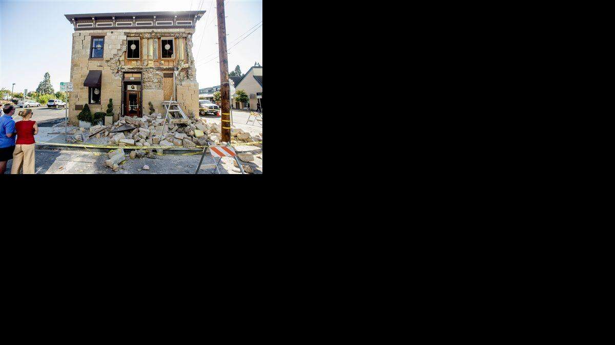  In this Aug. 24.file photo, pedestrians examine a crumbling facade following an earthquake at the Vintner's Collective tasting room in Napa.