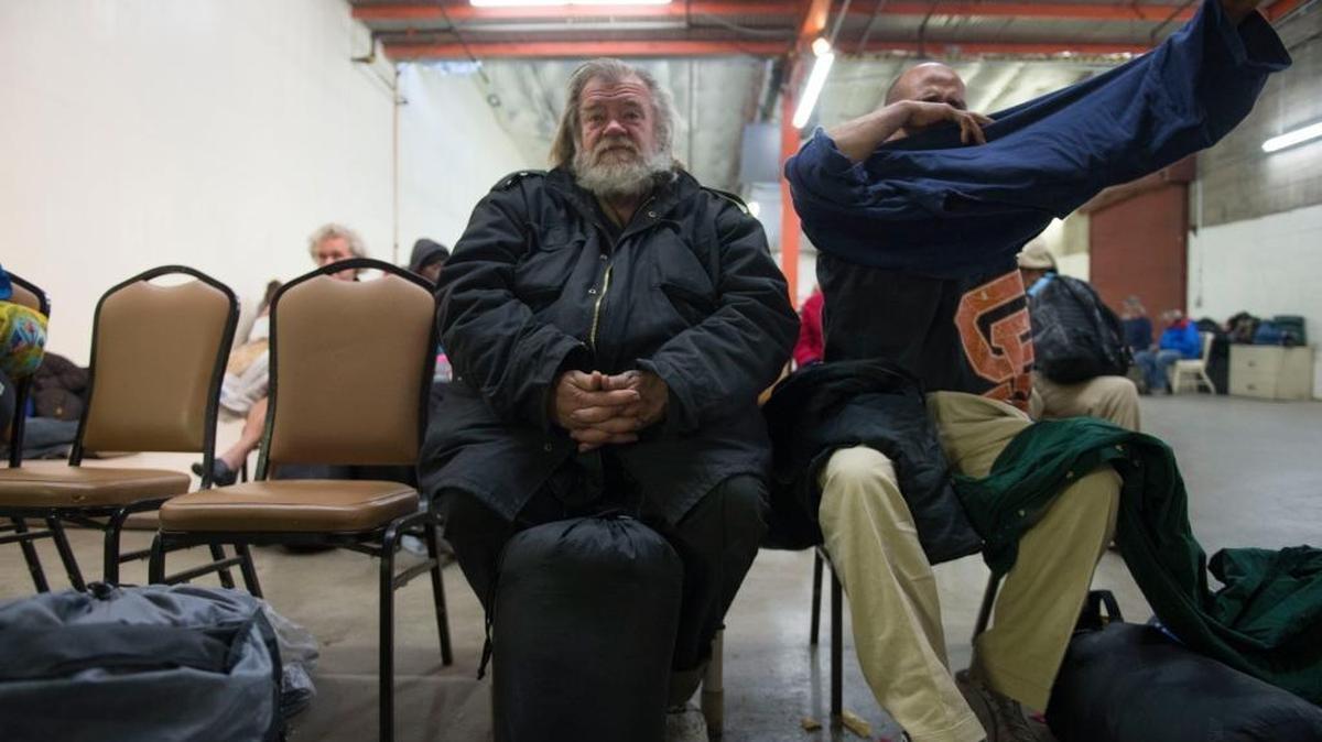 A homeless man named Doug who declined to give his last name, center, and others wait in a warehouse to be bused to a church where they will spend the night protected from the cold at Sac Steps Forward’s Winter Sanctuary Program, Sunday, November 29, 2015.