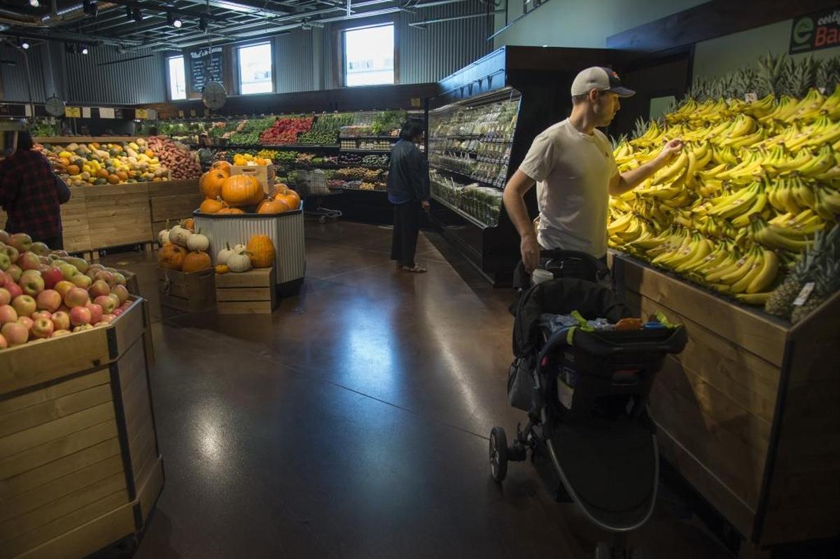 Zach Clevenger buys produce at the Sacramento Natural Foods Co-Op’s new location at 29th and R streets.