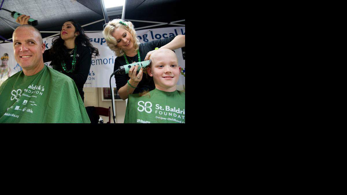 
Finnegan McCaffery, 8, right, was joined by his dad, Jeff McCaffery of Davis, Thursday, March 12, 2015, at de Vere's Irish Pub in Davis, to have their heads shaved by Supercuts stylists, Mayra Munoz, left, and Amber Joslin, right, during the St. Baldrick's event to raise money for childhood cancer research.
