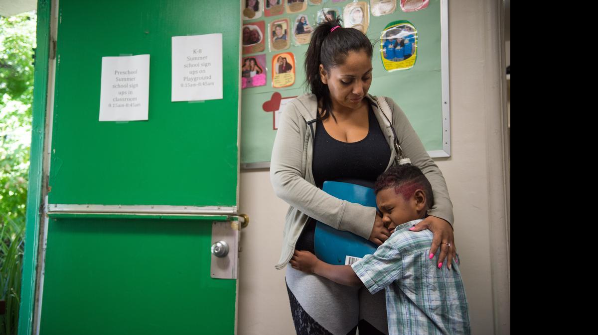 
Davida Gomez hugs her son, William Swilley, 5, who shows a little separation anxiety before going to class at the Mustard Seed School on Tuesday. 
