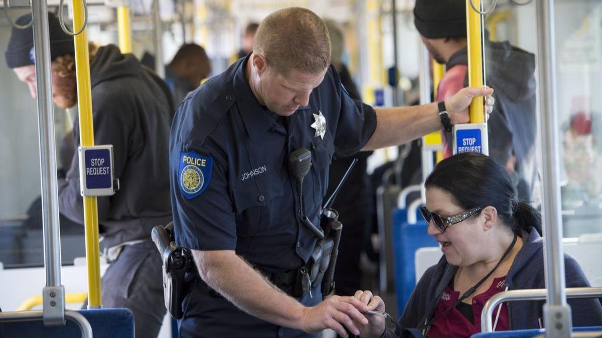 Sacramento police Officer Gus Johnson checks for valid tickets on a light-rail train on Feb. 8, 2015, at the 65th Street station.