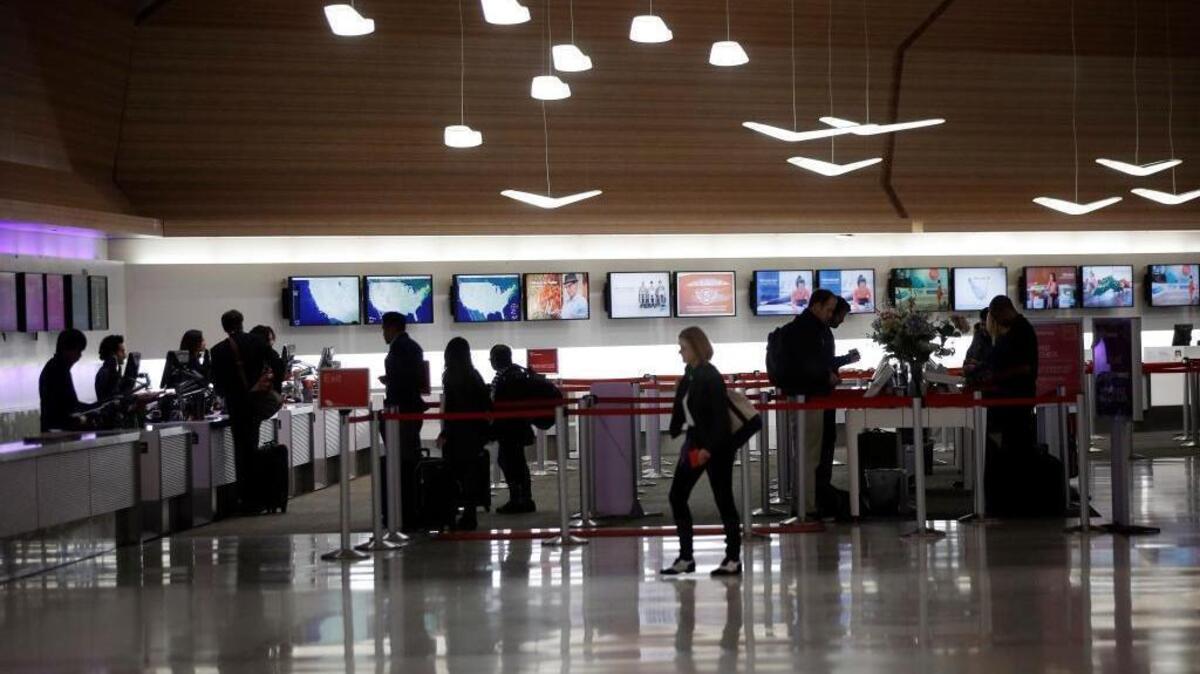 Travelers line up at a ticket counter at the San Francisco International Airport Sunday, Nov. 22, 2015, in San Francisco. (AP Photo/Marcio Jose Sanchez)