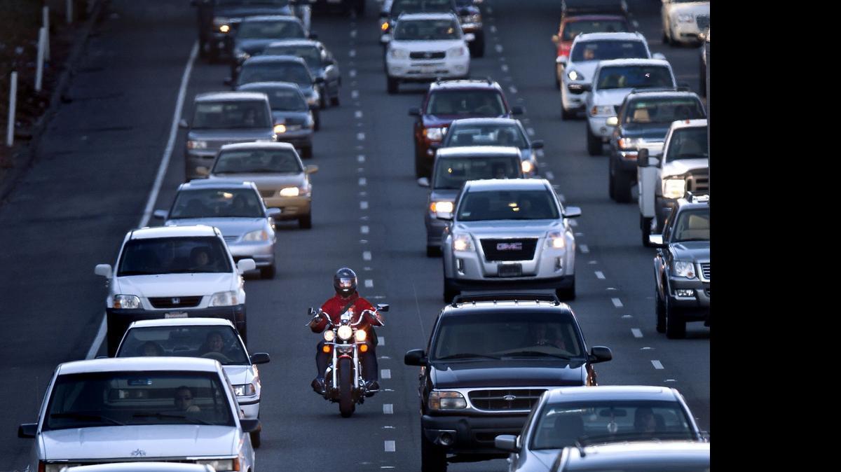 
A motorcyclist rides between the lanes during the afternoon commute on southbound Highway 99 in Sacramento. Assembly Bill 51 would put limits on the practice, which is not covered in the California Vehicle Code.
