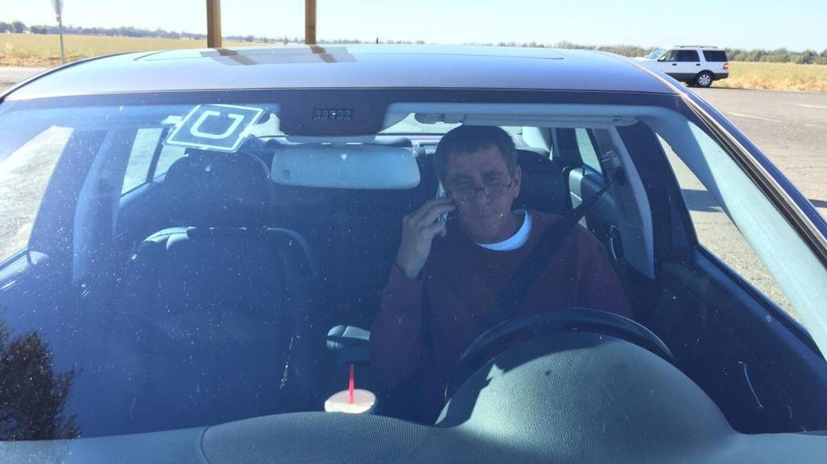 
Uber driver David Vasquez, parked just off airport grounds, arranges a ride for an arriving passenger.

