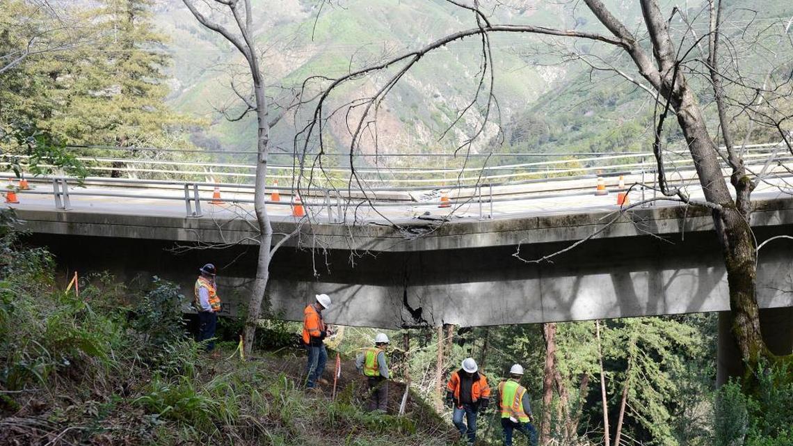 In this Wednesday, Feb. 22, 2017 photo, Caltrans engineers evaluate storm damage near a large crack where the Pfeiffer Canyon Bridge is sagging on Highway 1 in Big Sur, Calif.