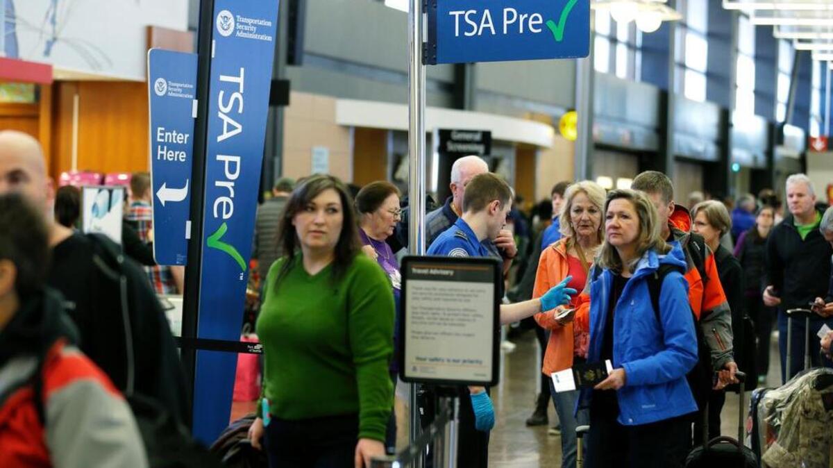 Travelers authorized to use the Transportation Security Administration’s PreCheck expedited security line at Seattle-Tacoma International Airport in Seattle have their documents checked by TSA workers on March 17.