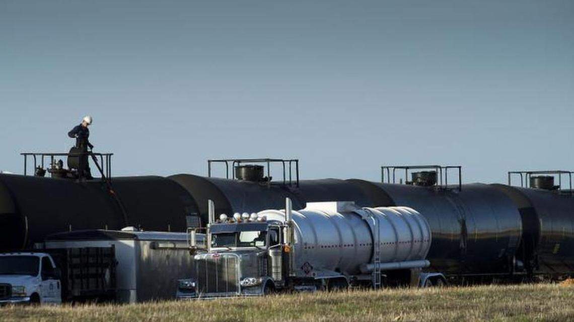 A tanker truck is filled from railway cars containing crude oil at McClellan Park in 2014.