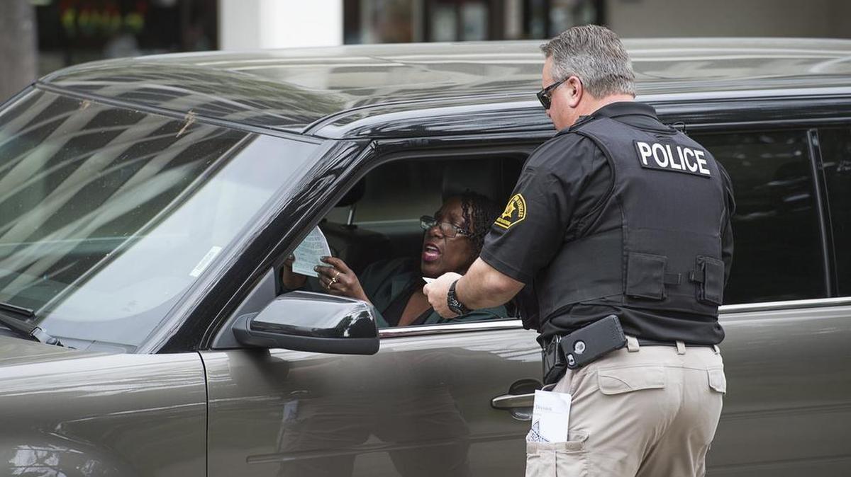 Elnora Fretwell shows DMV investigations supervisor Tom Edwards her permit for her disabled person parking placard during an enforcement operation Wednesday in downtown Sacramento.