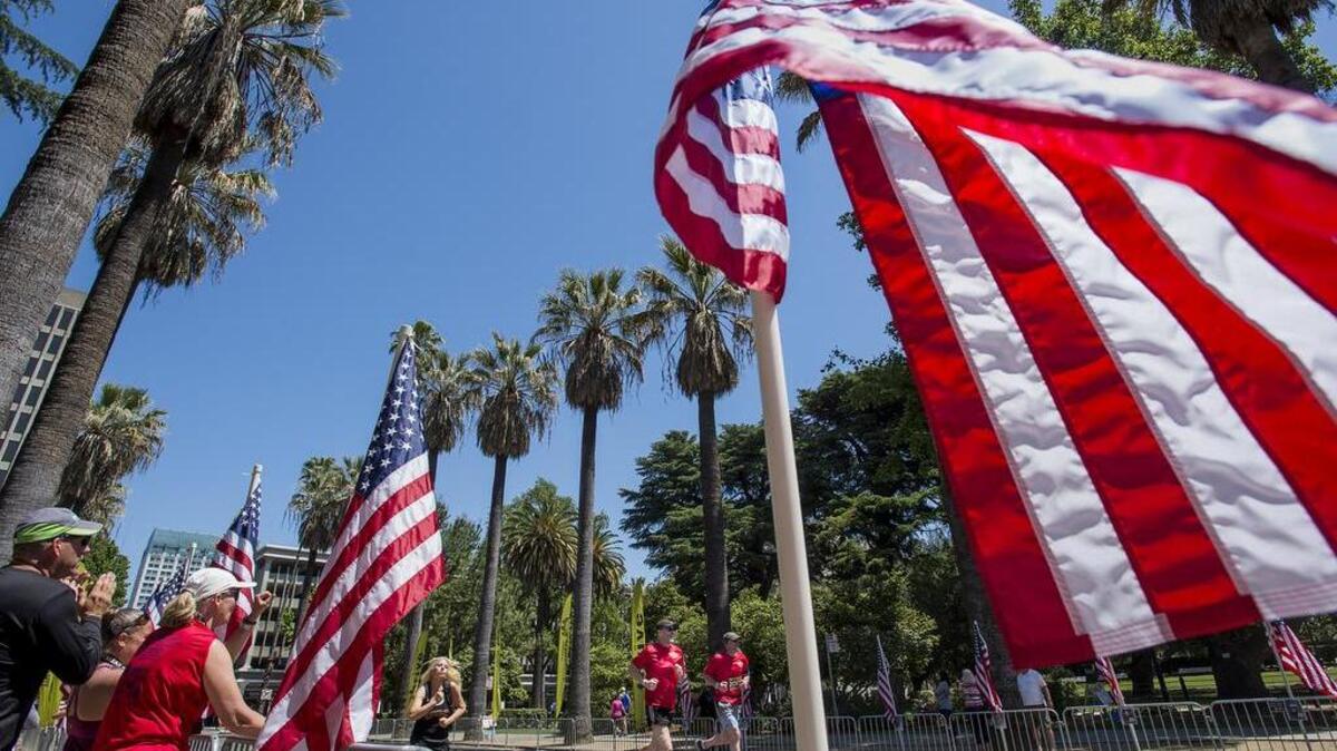 Alun Wynne, center, and Steve Klein, right, finish the Pony Express Marathon together at the state Capitol on Sunday, May 1, 2016, in Sacramento.