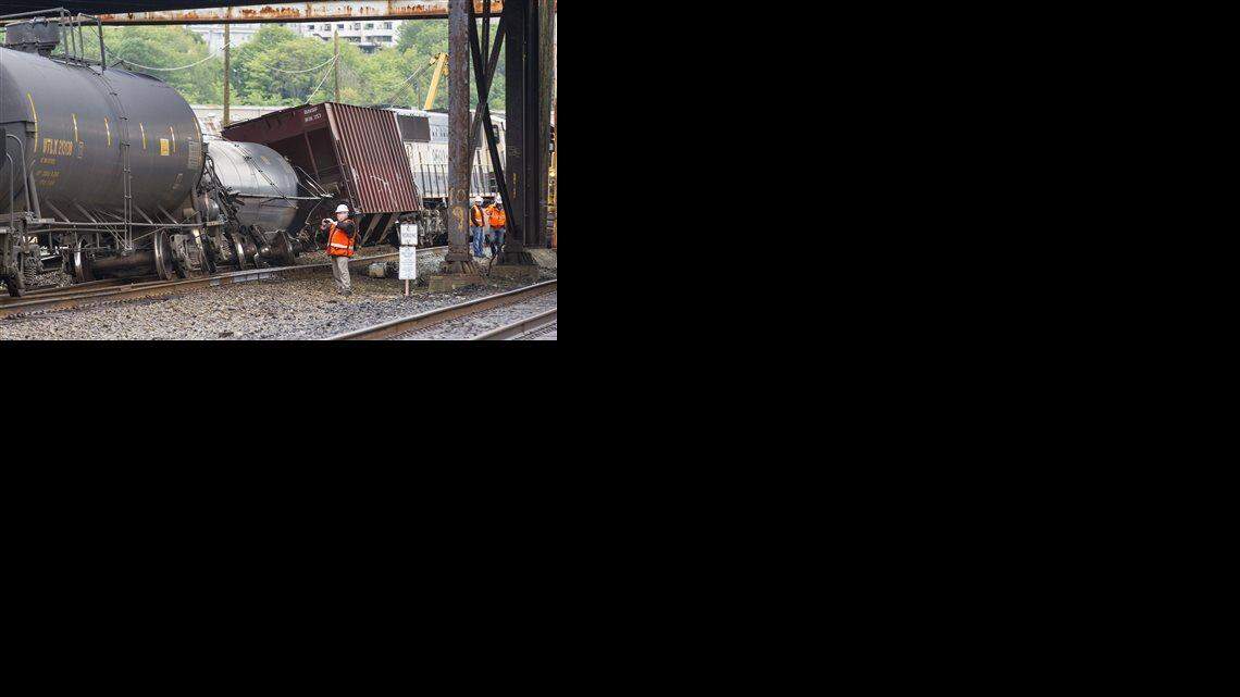 
In this July 24, 2014 file photo, an investigator photographs the scene where a locomotive and cars carrying crude oil went off the track beneath the Magnolia Bridge in Seattle. 
