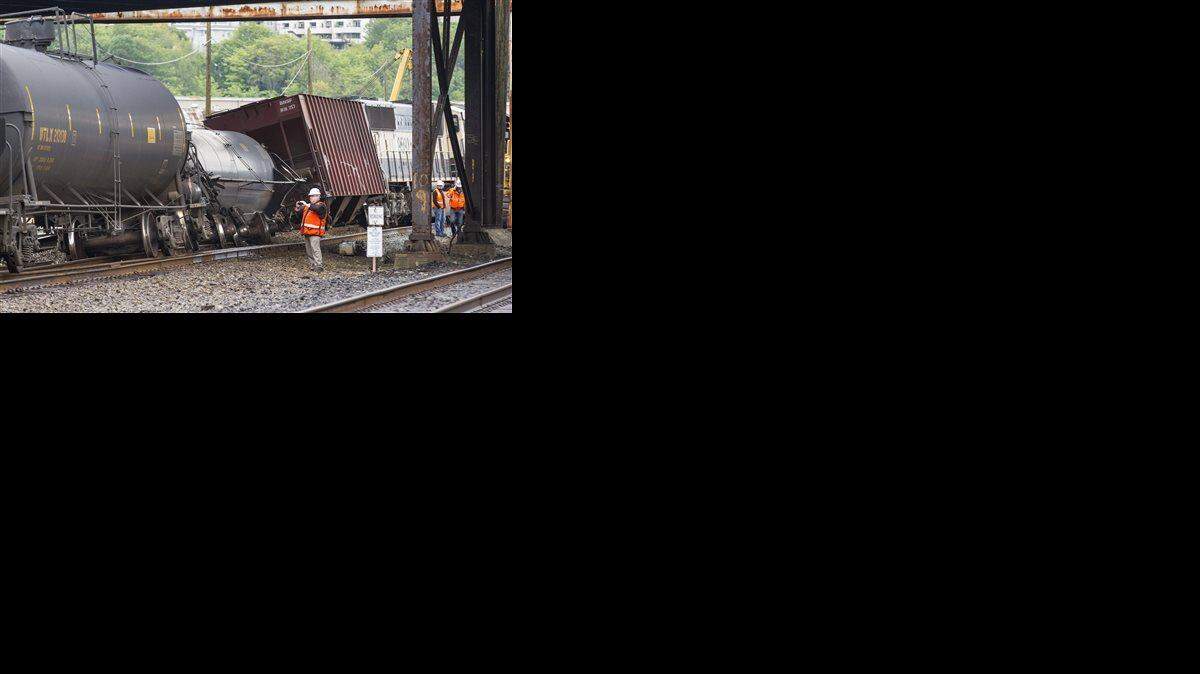 
In this July 24, 2014 file photo, an investigator photographs the scene where a locomotive and cars carrying crude oil went off the track beneath the Magnolia Bridge in Seattle. 
