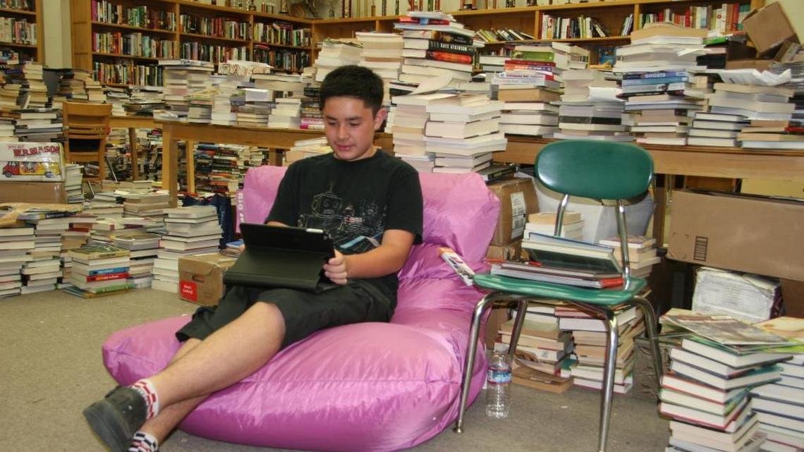 Diego Garcia, a ninth-grader at Indian Valley Academy, reclines on a beanbag chair donated to the Greenville library project.