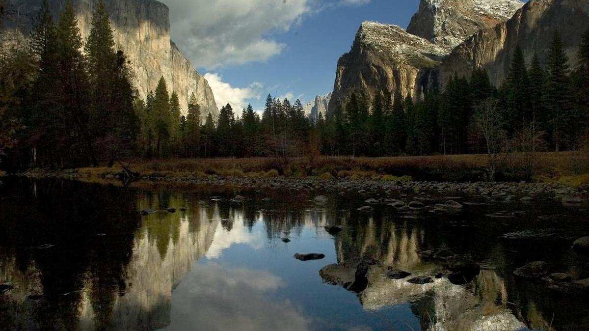 FILE - El Capitan, left, and the Cathedral Rocks, right, are reflected in the Merced River in Yosemite National Park in late November 2006. 