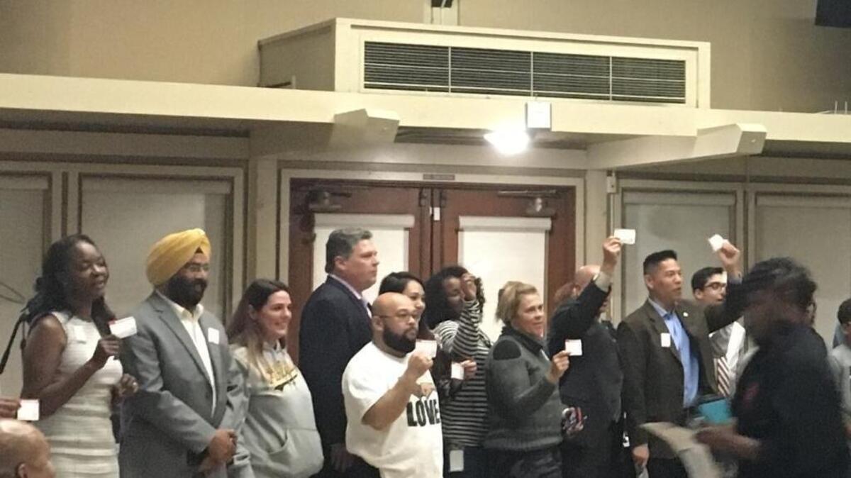 Elk Grove residents who spent four hours discussing racism in their city hold up pledges to stand against hate in the community on Monday, Oct. 23, 2017.