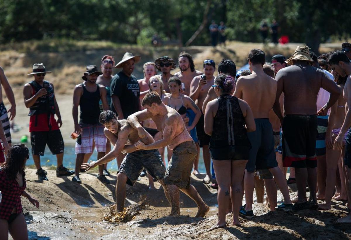 Robert Klabbatz of Berkeley mud wrestles on "Gilligan's Island," a small spot of land across from Ancil Hoffman Park on Saturday, July 11, 2015, in Rancho Cordova, Calif.