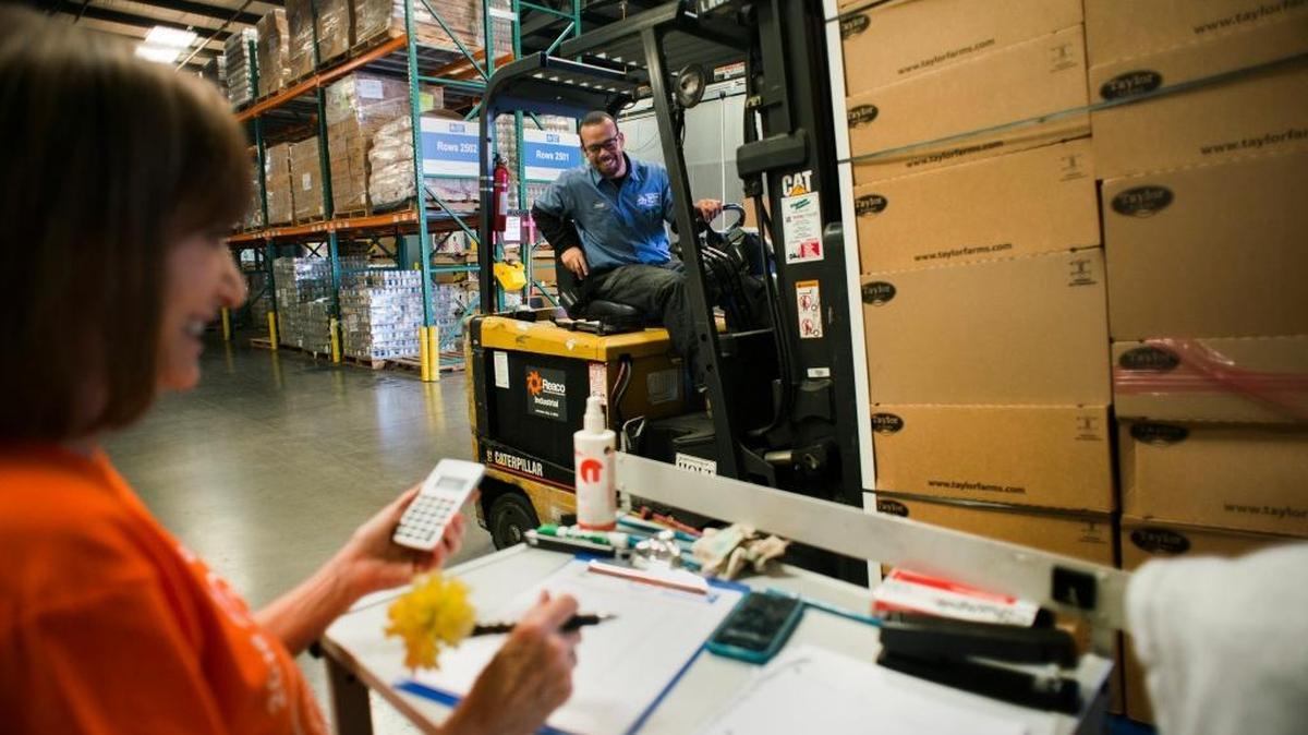 FILE -- Sacramento Food Bank & Family Services volunteer, Judy Clark, left, smiles at Warehouse Assistant, Aaron Smith as he places places food onto a scale to be weighed during a Guinness Book of World Record attempt in progress at the Sacramento Food Bank & Family Service's distribution center on Wednesday Sept. 7, 2016.