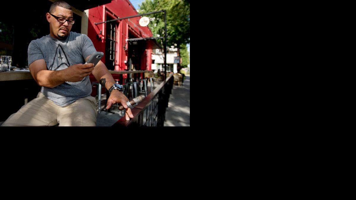 
Donavon Stauff, 34, instagrams his cigar butt to share with his cigar friends outside R15 on R Street in midtown Sacramento in 2014. Sacramento councilman Steve Hansen proposed a ban on smoking on patios at bars and restaurants, but the City Council decided to study the issue at the time. Folsom is considering a similar ban.
