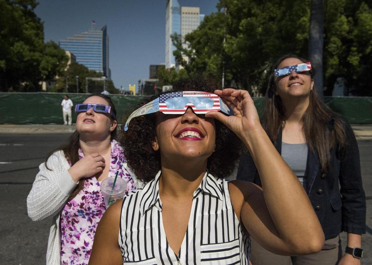 Emily Whitney, Courtney McKinney and Maya Aramouni, all of Sacramento, watch the partial solar eclipse near the state Capitol on Aug. 21, 2017.