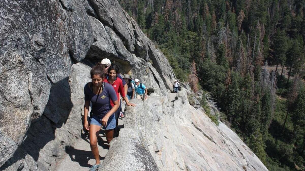 In celebration of its 100th anniversary, the National Park Service is waiving park entrance fees for the next two weekends. Saturday and Sunday, plus April 22 and 23, will be free days at the 118 national parks that normally charge an entrance fee. Pictured are hikers climbing the 400-step stairway carved into Moro Rock in Sequoia National Park.