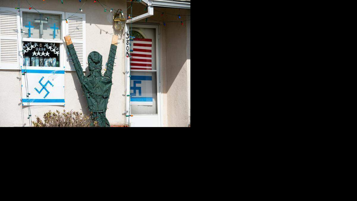 
A home on Moddison Avenue in Sacramento’s River Park neighborhood displays a depiction of the American flag with a swastika replacing the stars Thursday. Anther flag on display replaces the Star of David with a swastika. e 
