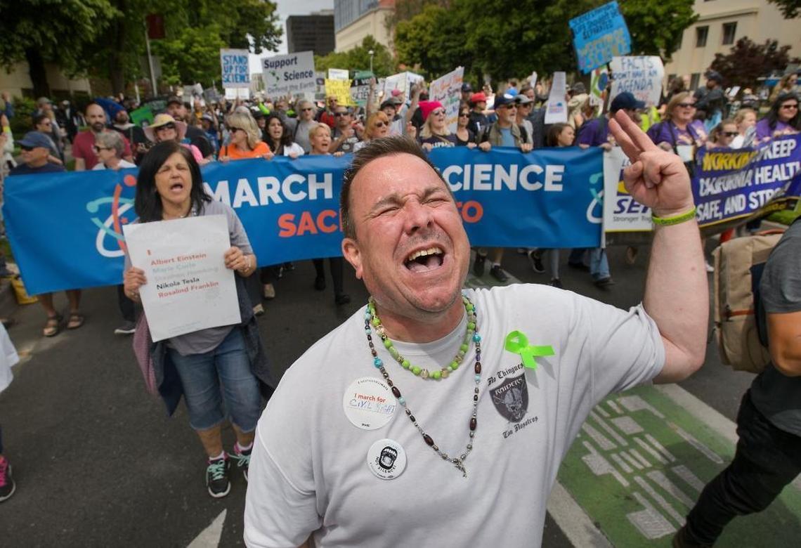 Thousands of marchers, including Bruce Fields of Sacramento, center, chant slogans as they proceed up Capitol Mall during the March for Science in Sacramento on Saturday.