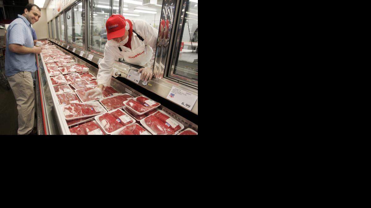 
A customer watches a butcher at a Costco in Mountain View.
