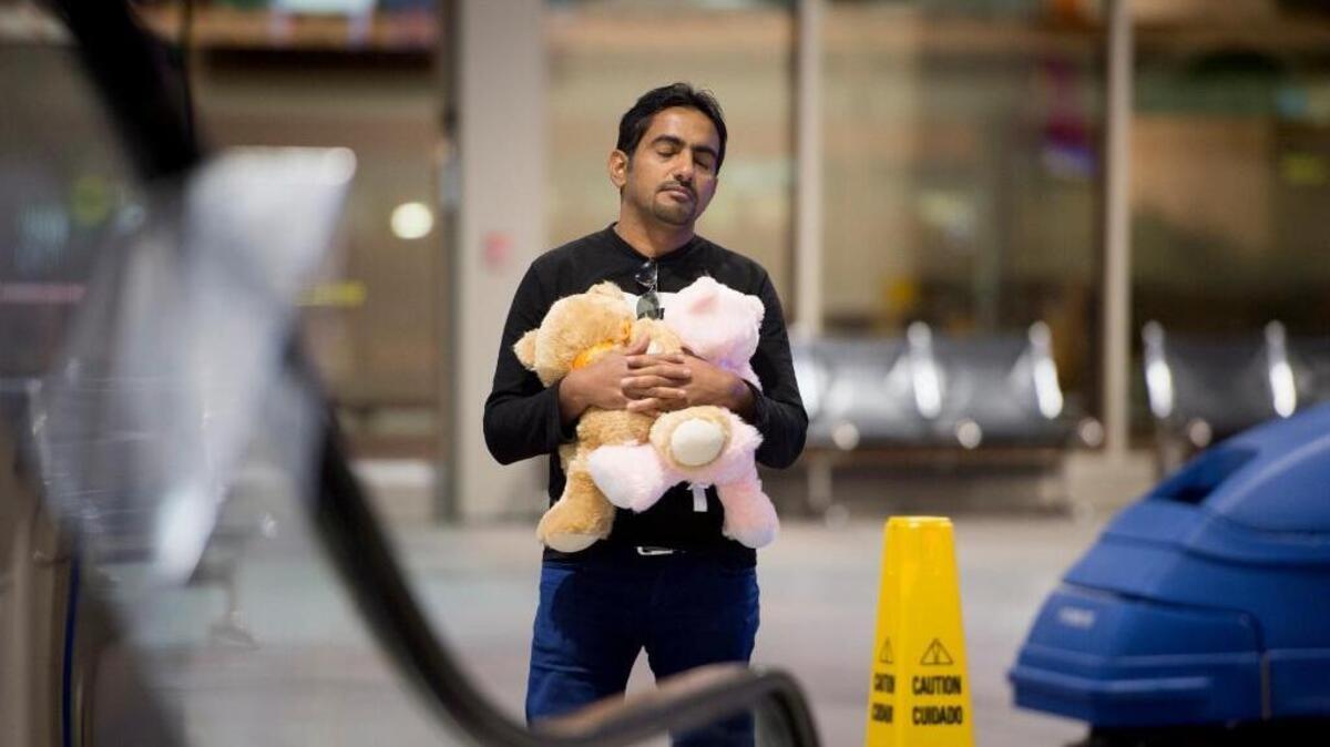 Taha Hammood clutches teddy bears as he waits to be reunited with his wife and two children early Wednesday, Oct. 21, in the baggage claim area of Sacramento International Airport. Hammond, a wounded Iraqi war refugee, came to Sacramento two years ago, still suffering from injuries from a car bomb in Baghdad.
