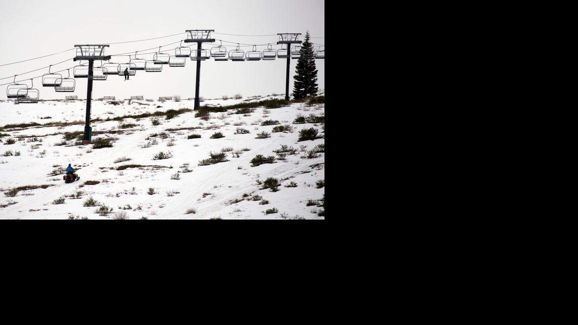 
A skier rides up the Eagle Rock chairlift to the summit at Tahoe Donner ski area in January. The run below the chairlift, and many others have been closed due to lack of snowfall. Sierra at Tahoe has announced it is closing, at least temporarily. It is the fifth of 14 operators closing early due to lack of snow.
