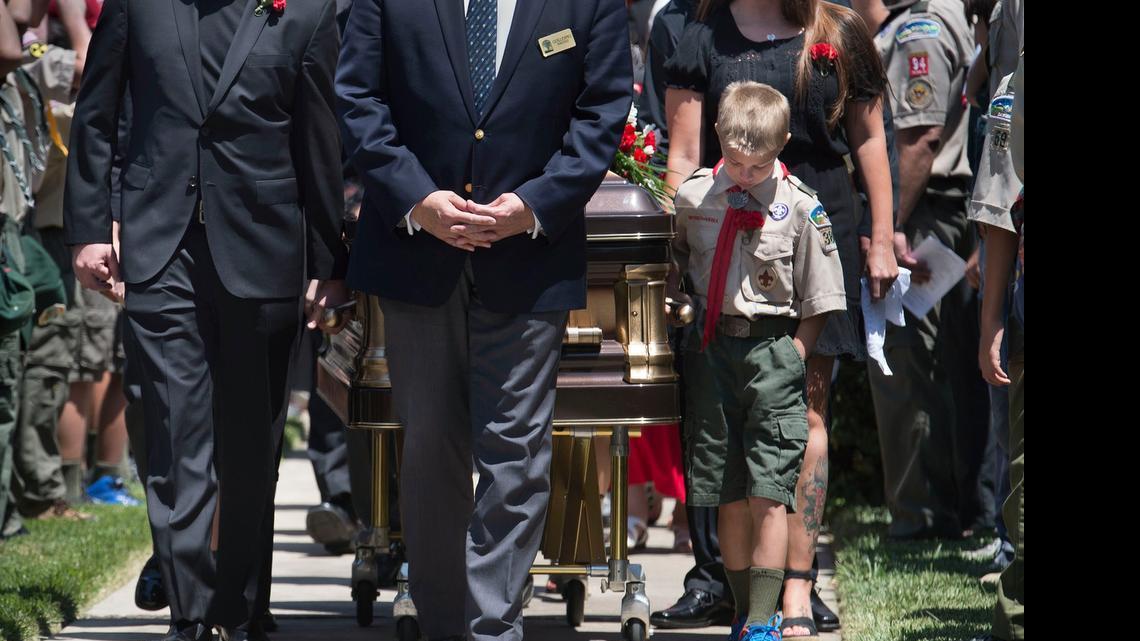 
As fellow Boy Scouts salute and line the walkway, Russell Brock, 11, leads the casket of his older brother Alden Brock, 13, from a memorial service at the Church of Jesus Christ of Latter-day Saints on Wednesday. Alden Brock was killed in a flash flood while camping with his troop in New Mexico late last month.
