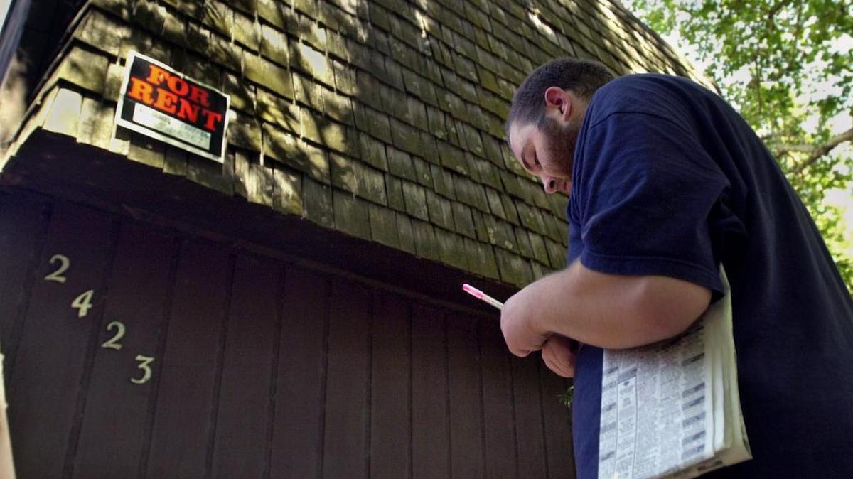 File photo: Brian Brashear writes down the number for an apartment for rent in midtown on Aug. 17, 2001.