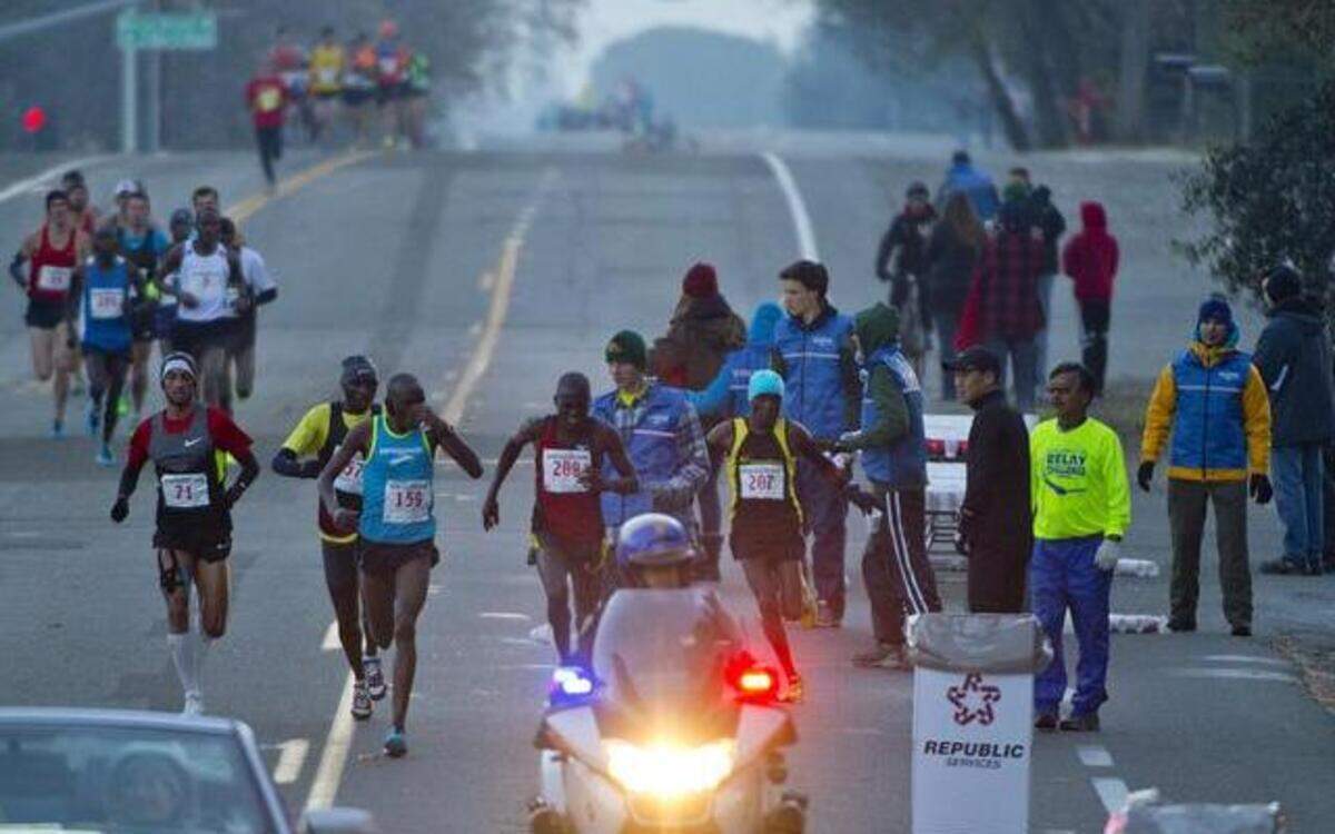 
Runners take water during the 2013 California International Marathon. This year’s race is Sunday, Dec. 7.
