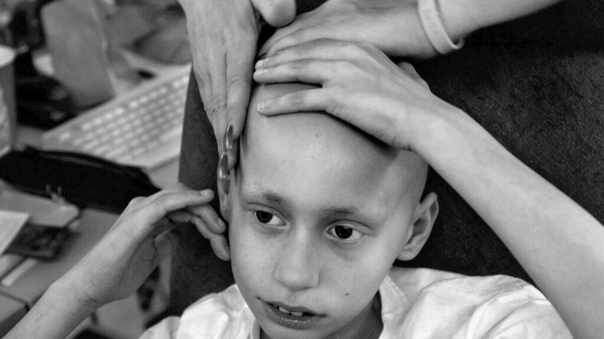 Derek Madsen, 10, gets a soothing massage from his mother, Cyndie French, at her Sacramento nail and tanning salon on June 2, 2005. The 10-year-old is battling a rare childhood cancer that has invaded his bones and organs. "I'm going to do whatever it takes to make him happy, to see him smile." Cyndie says. Cyndie, a single mom, had to give up her salon to care for her dying son.