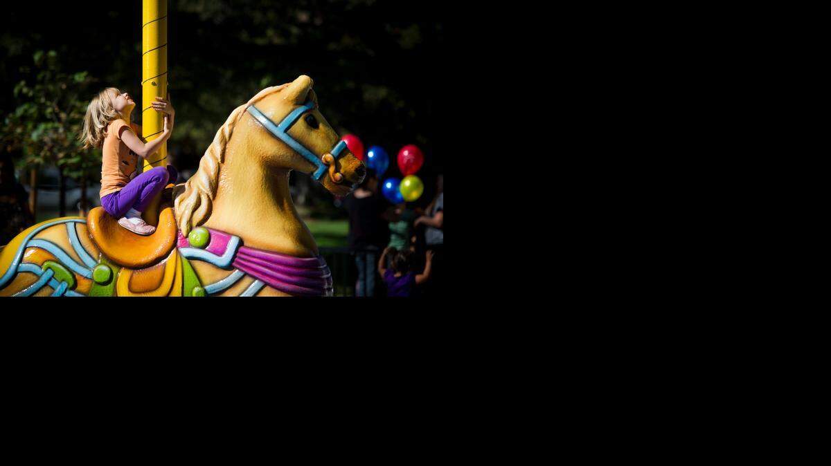 
Ellyn Kuyper, 7, sits on one of three stationary carousal carousel horses at Oak Park’s newly renovated James McClatchy Park. on Saturday, Oct. 18, 2014, during the park’s grand opening celebration. The landmark underwent a $2.8 million renovation.
