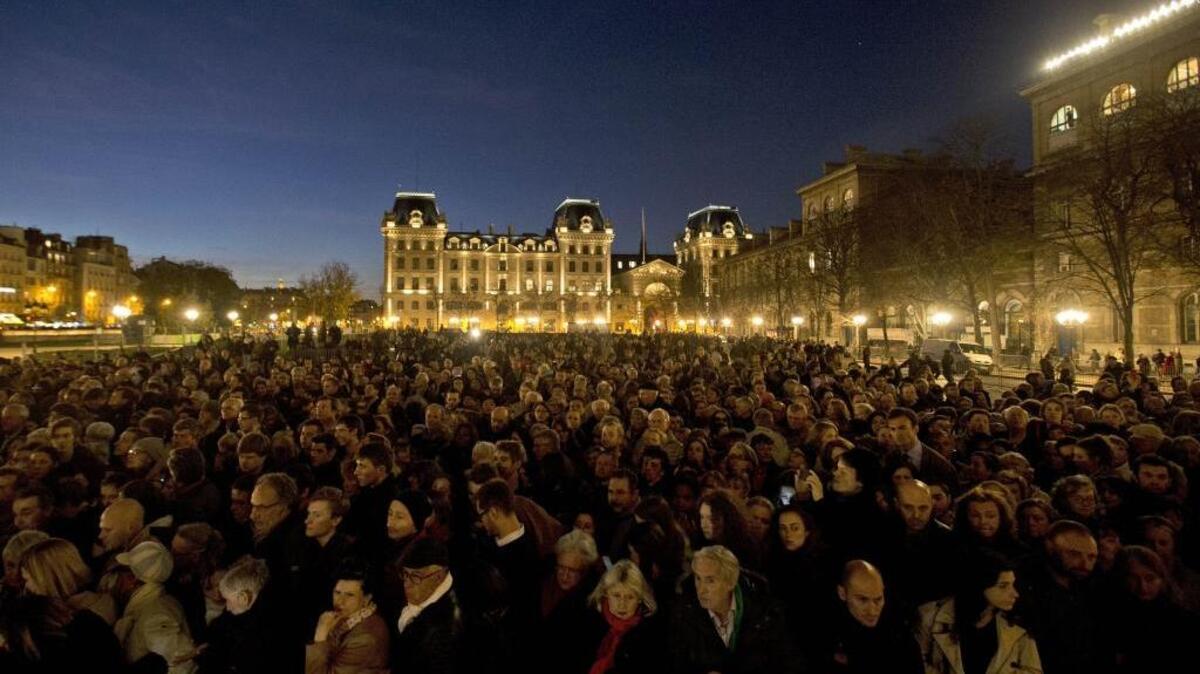 People gather for a national service for the victims of the terror attack at Notre Dame cathedral in Paris, Sunday, Nov. 15, 2015. Thousands of French troops deployed around Paris on Sunday and tourist sites stood shuttered in one of the most visited cities on Earth while investigators questioned the relatives of a suspected suicide bomber involved in the country's deadliest violence since World War II.