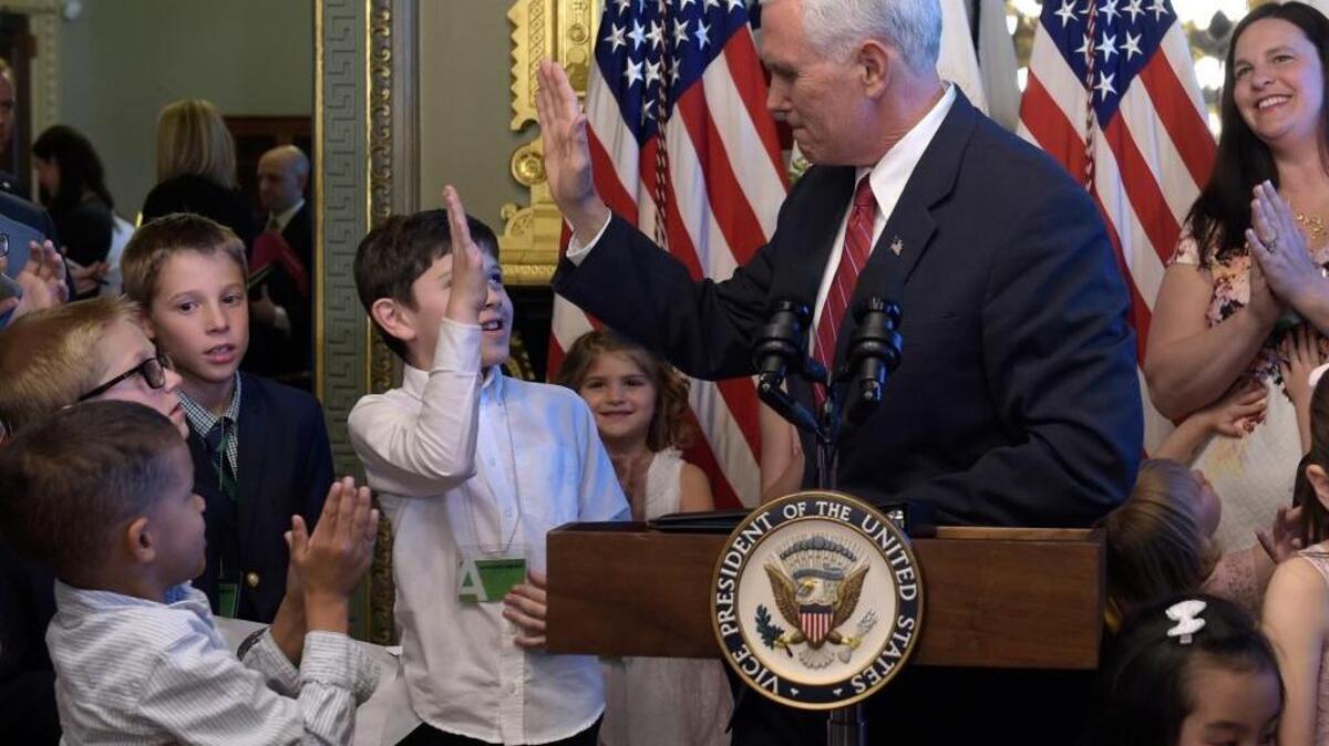 Vice President Mike Pence gets a high-five from a boy after speaking Tuesday during an event celebrating National Military Appreciation Month and National Military Spouse Appreciation Day. Pence accidentally hit the boy in the face, and the child demanded an apology.