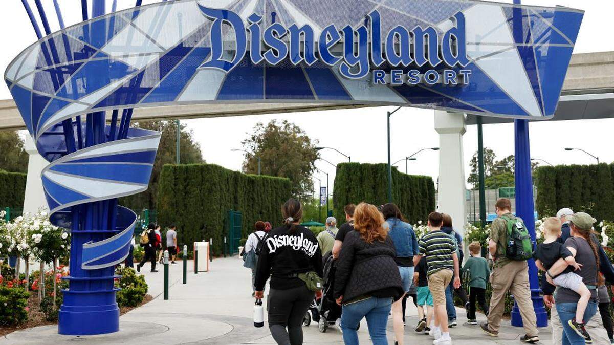 ANAHEIM, CALIFORNIA - APRIL 24: People walk toward an entrance to Disneyland on April 24, 2023 in Anaheim, California. Disney will lay off several thousand workers this week amid an overall push by the media giant to cut 7,000 total jobs in an effort to save $5.5 billion in costs. (Photo by Mario Tama/Getty Images)