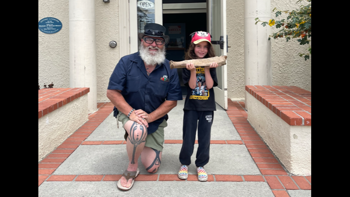 Wayne Thompson, a paleontologist with the museum, poses for a photo with one of the students who discovered the ancient floth fossil.