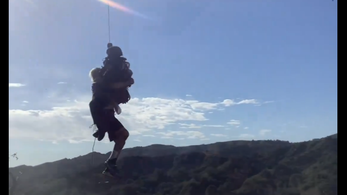 A man who stumbled off a cliff while chasing after his pet parrot was rescued, California officials say.