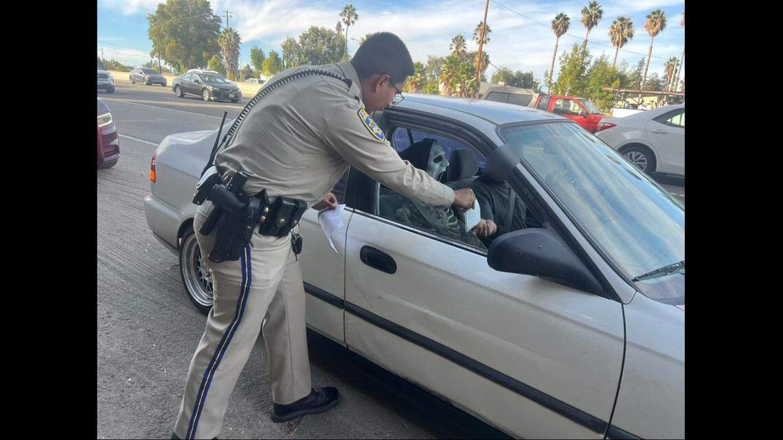 A photo shared by CHP shows an officer handing the driver what appears to be a ticket.