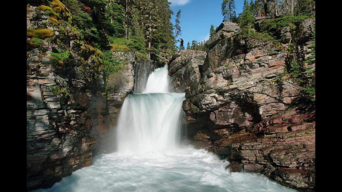 A 26-year-old tourist drowned after being carried over a waterfall at Glacier National Park, Montana rangers say.