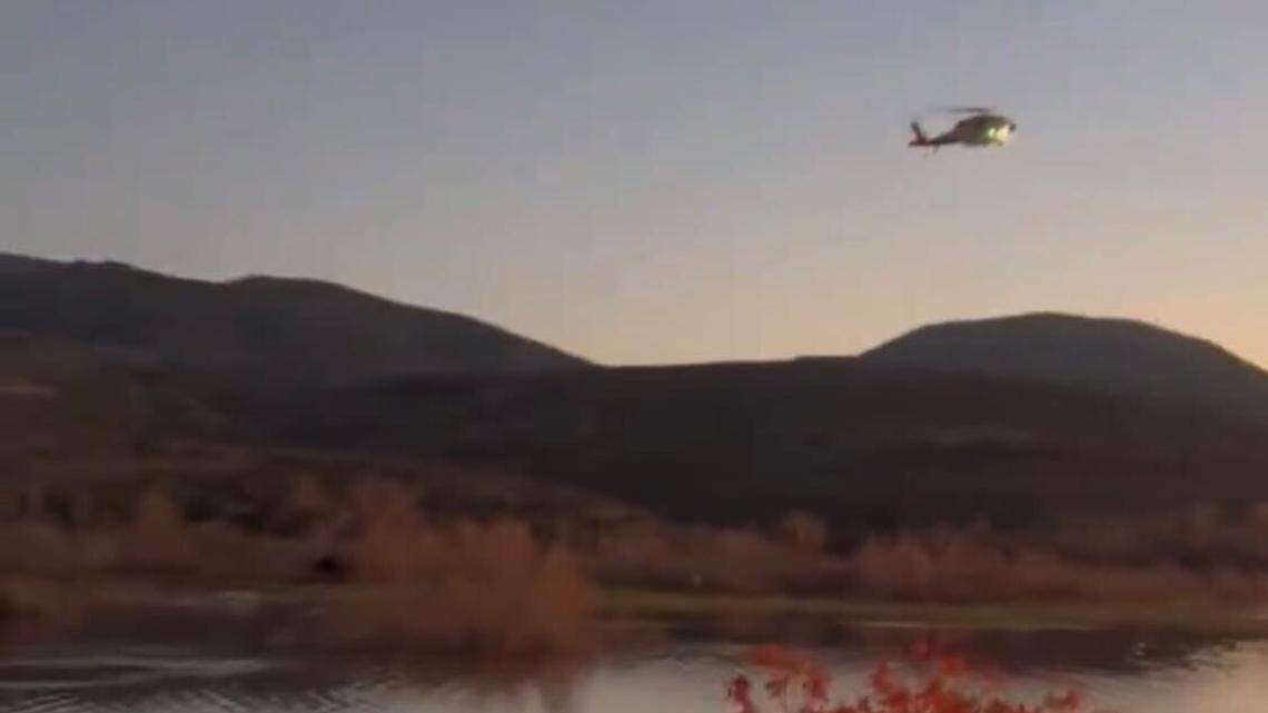 Rescuers race setting sun to save duo stranded in tree surrounded by water, officials say